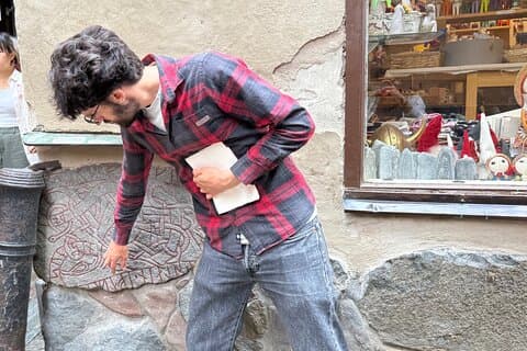A local guide points out the hidden runestone in Stockholm’s Old Town – a relic from the Viking Age tucked into a medieval wall.
