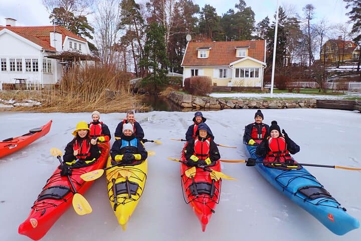 Taking a fika break surrounded by snow-covered islands after a winter kayaking adventure near Stockholm