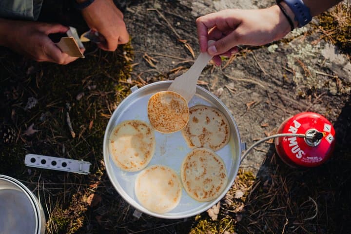 Camp cooking moment — outdoor lunch prep on a tiny archipelago island during our 2-day guided kayak & wild camp tour.